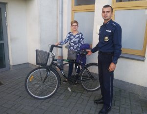 Asp szt. Artur Kędzierski przekazuje odzyskany rower właścicielce.