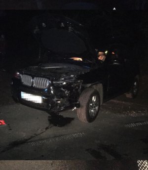 Pojazd marki BMW, który został uszkodzony w rezultacie kolizji. Spod pojazdu wyciekają płyny eksploatacyjne.