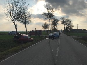 Fragment drogi relacji Żnin - Janowiec Wielkopolski. na lewym pasie jezdni uszkodzony pojazd marki Fiat, z lewej strony w rowie samochód marki Renault. W oddali widoczny radiowóz policyjny oraz wóz strażacki, a także funkcjonariusze kierujący ruchem.